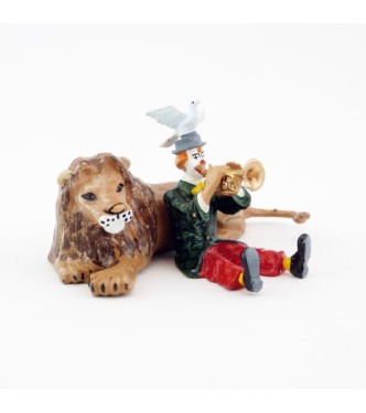 clown jouant de la trompette assis devant un lion