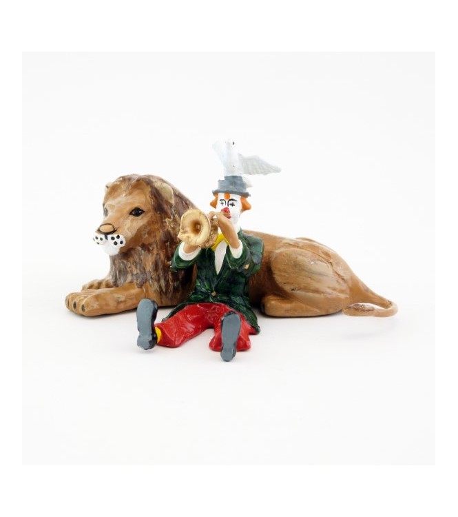 clown jouant de la trompette assis devant un lion