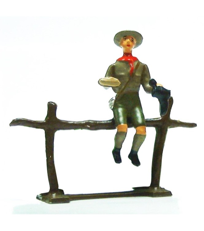 scout assis sur barrière cirant chaussure