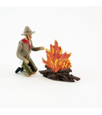 scout à genoux devant un feu de bois