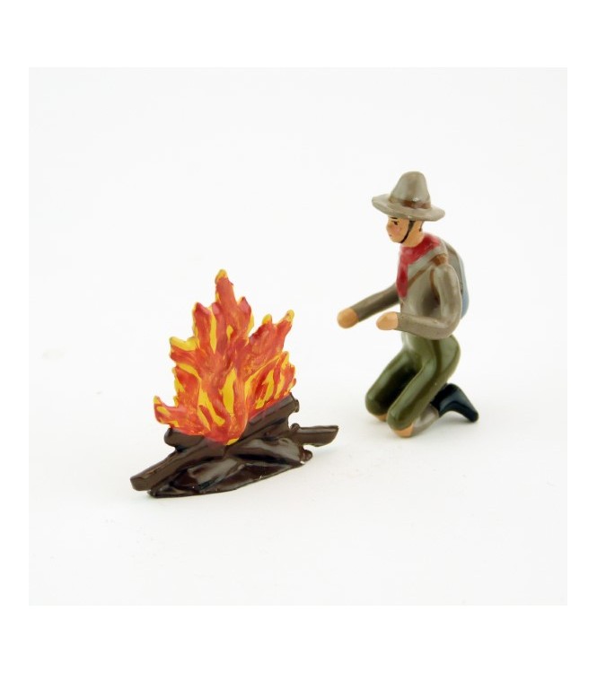 scout à genoux devant un feu de bois
