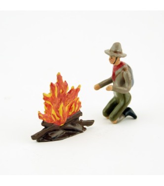 scout à genoux devant un feu de bois