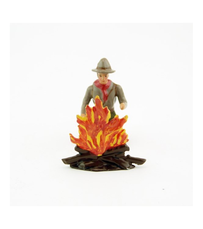 scout à genoux devant un feu de bois