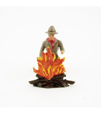 scout à genoux devant un feu de bois