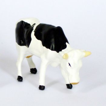 Vache blanche et noire brouttant