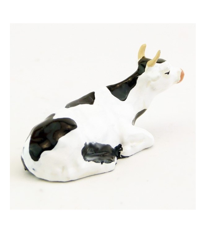 Vache blanche et noire couchée