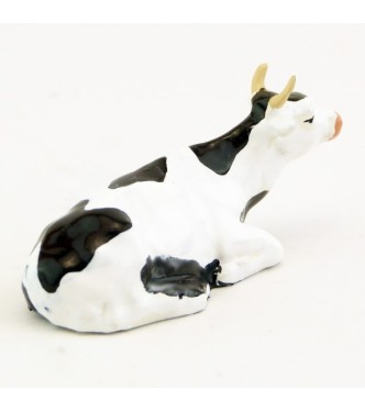 Vache blanche et noire couchée