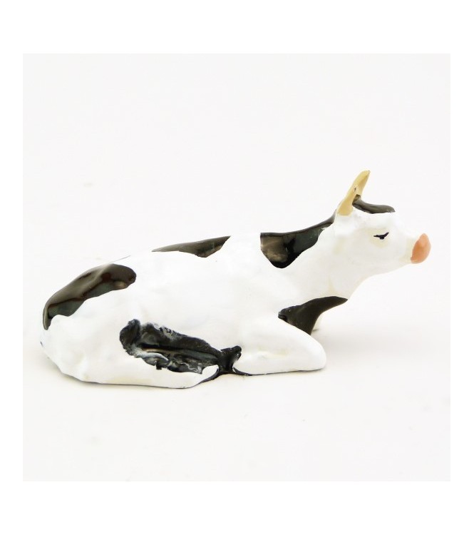 Vache blanche et noire couchée