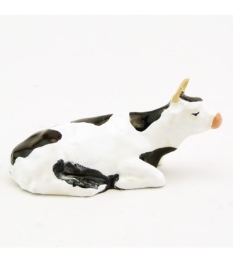 Vache blanche et noire couchée