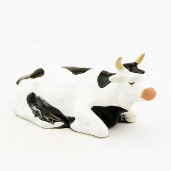 Vache blanche et noire couchée