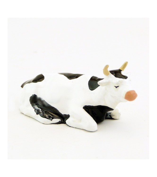 Vache blanche et noire couchée