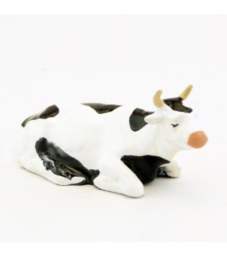 Vache blanche et noire couchée
