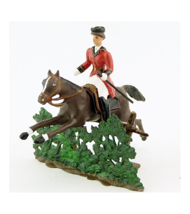 cavalière (cravache) sur cheval marron sautant haie + barrière