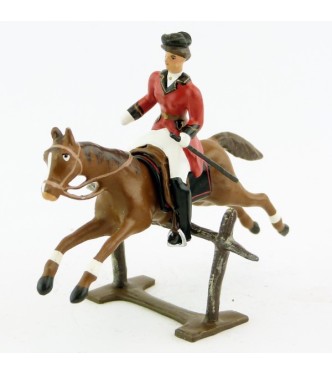 cavalière (cravache) sur cheval alezan sautant barrière