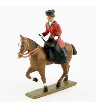 cavalière en amazone sur cheval alezan au pas