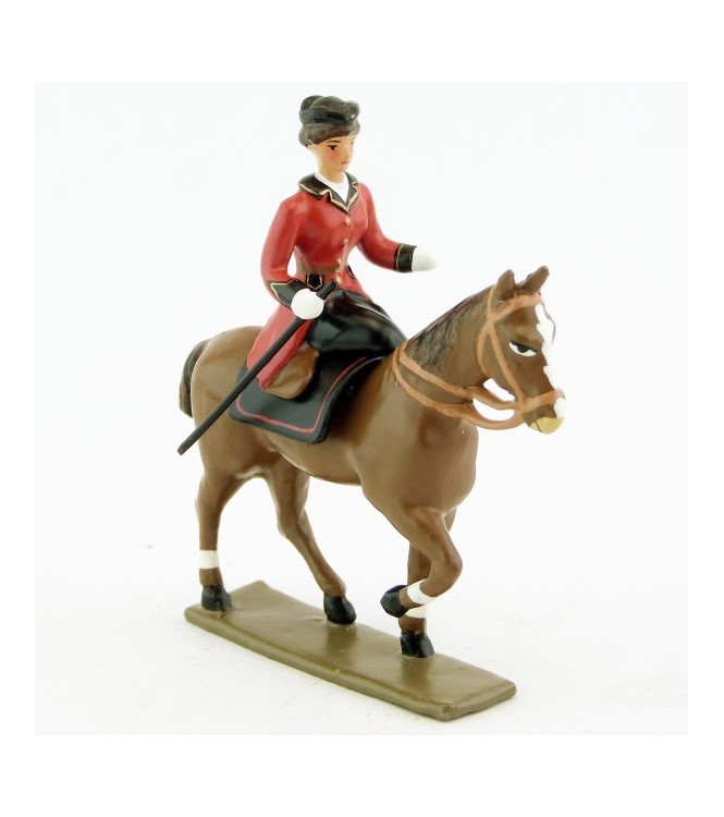 cavalière en amazone sur cheval alezan au pas