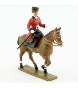 cavalière en amazone sur cheval alezan au pas