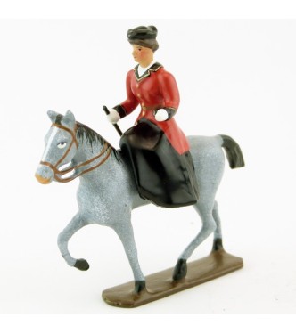 cavalière en amazone sur cheval gris au pas