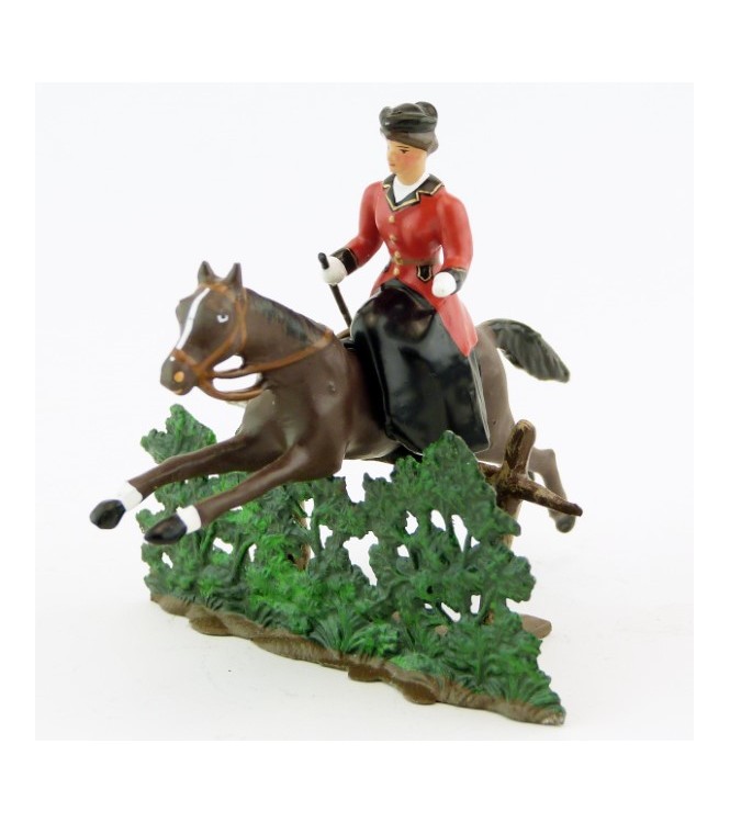 cavalière en amazone sur cheval marron (bai) sautant haie + barrière