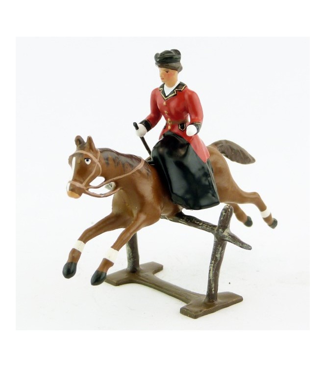 cavalière en amazone sur cheval alezan sautant barrière