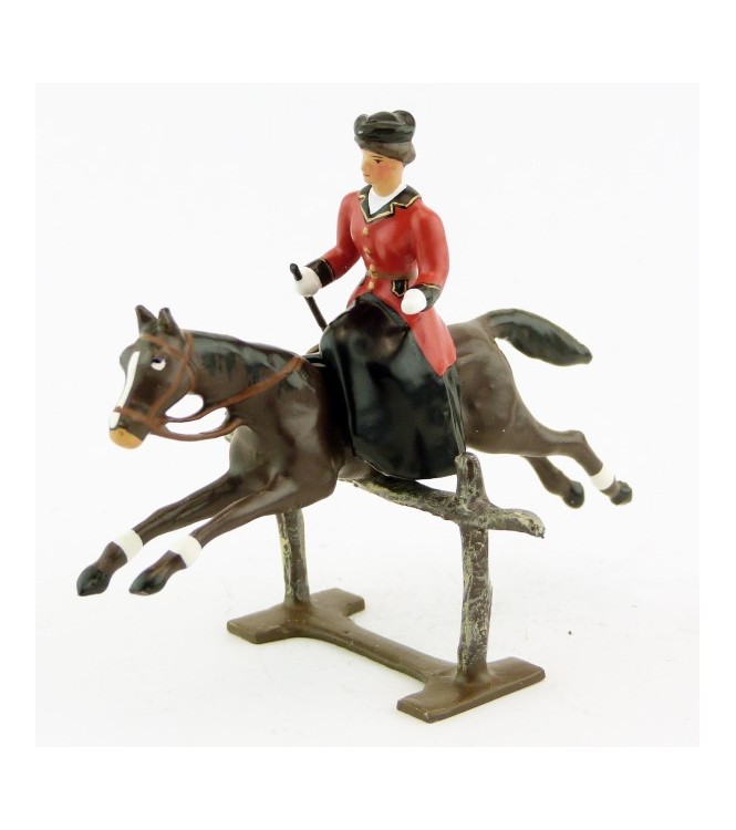 cavalière en amazone sur cheval marron (bai) sautant barrière