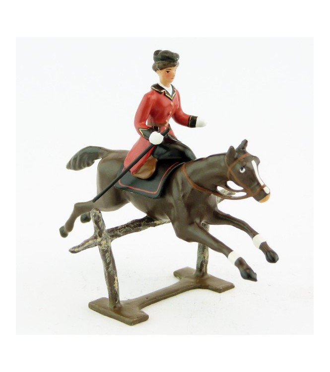 cavalière en amazone sur cheval marron (bai) sautant barrière