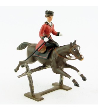 cavalière en amazone sur cheval marron (bai) sautant barrière