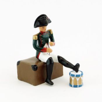 Napoléon assis sur un coffre, pied posé sur un tambour