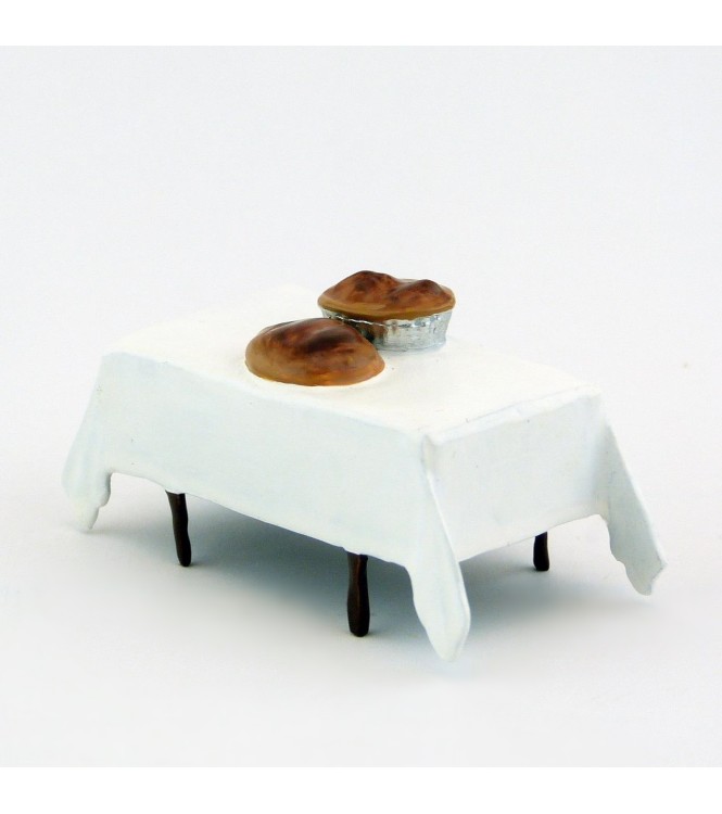 table avec nappe blanche et miches de pain