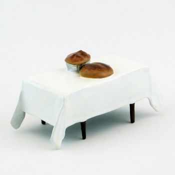 table avec nappe blanche et miches de pain