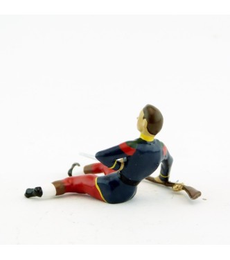 légionnaire blessé, assis au sol, main sur le cœur, avec fusil