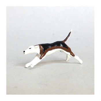 Chien de chasse à courre (Beagle) courant par-dessus un buisson